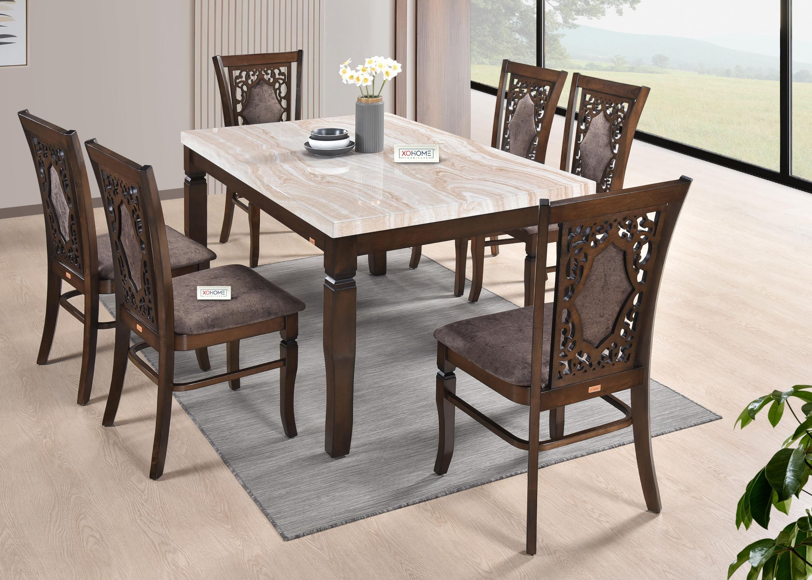 Carmen 6-seater dining set by XOHOME with a marble finish veneer top and intricately carved solid wood chairs with cushioned, padded backs. Luxurious and durable design.